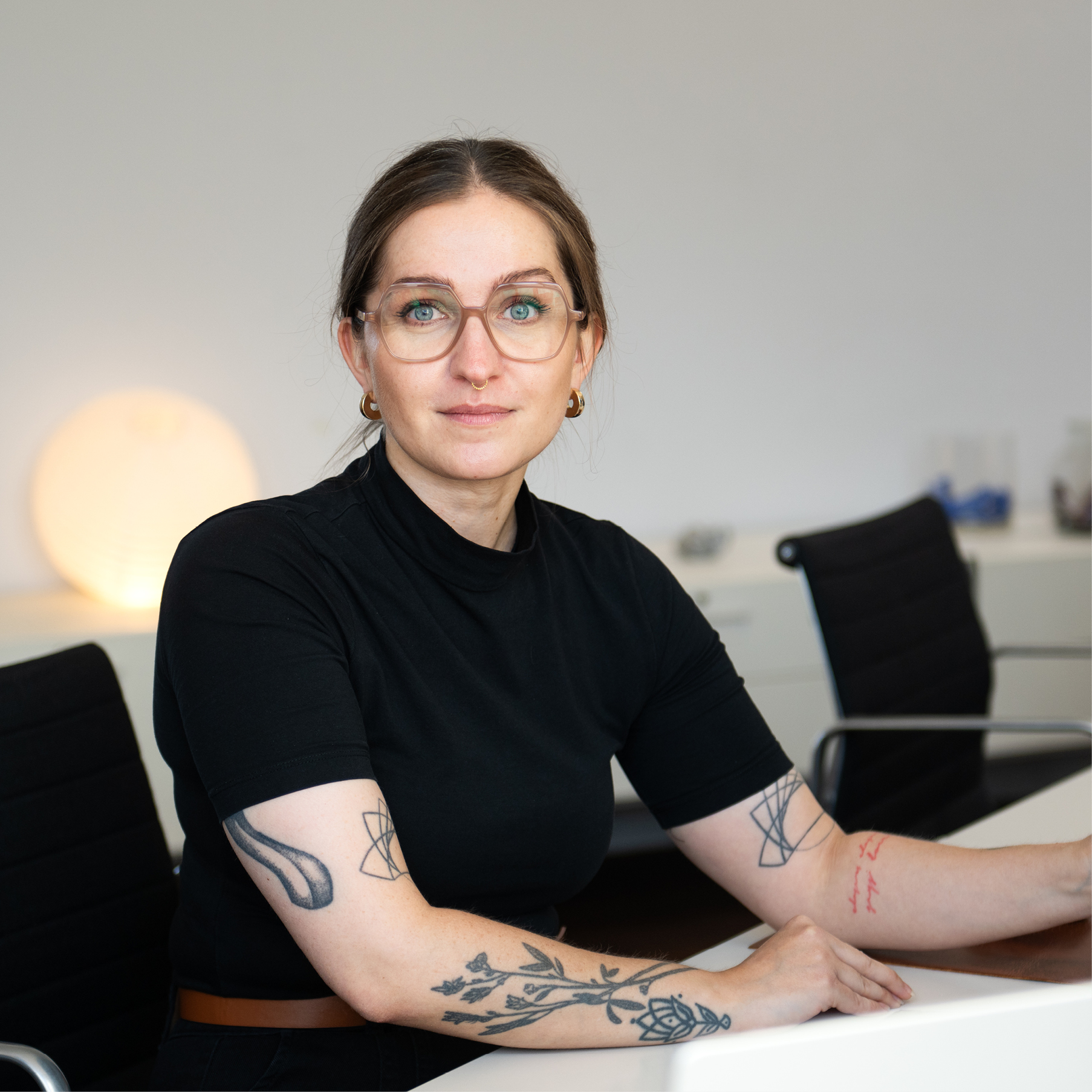 Lydia Busch am Arbeitsplatz sitzend, der Kamera freundlich zugewandt