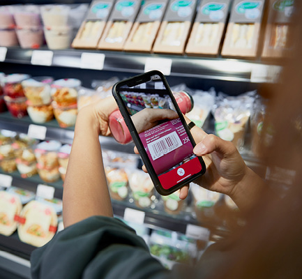 Kundin scannt den Barcode eines Produktes mit ihrem Smartphone